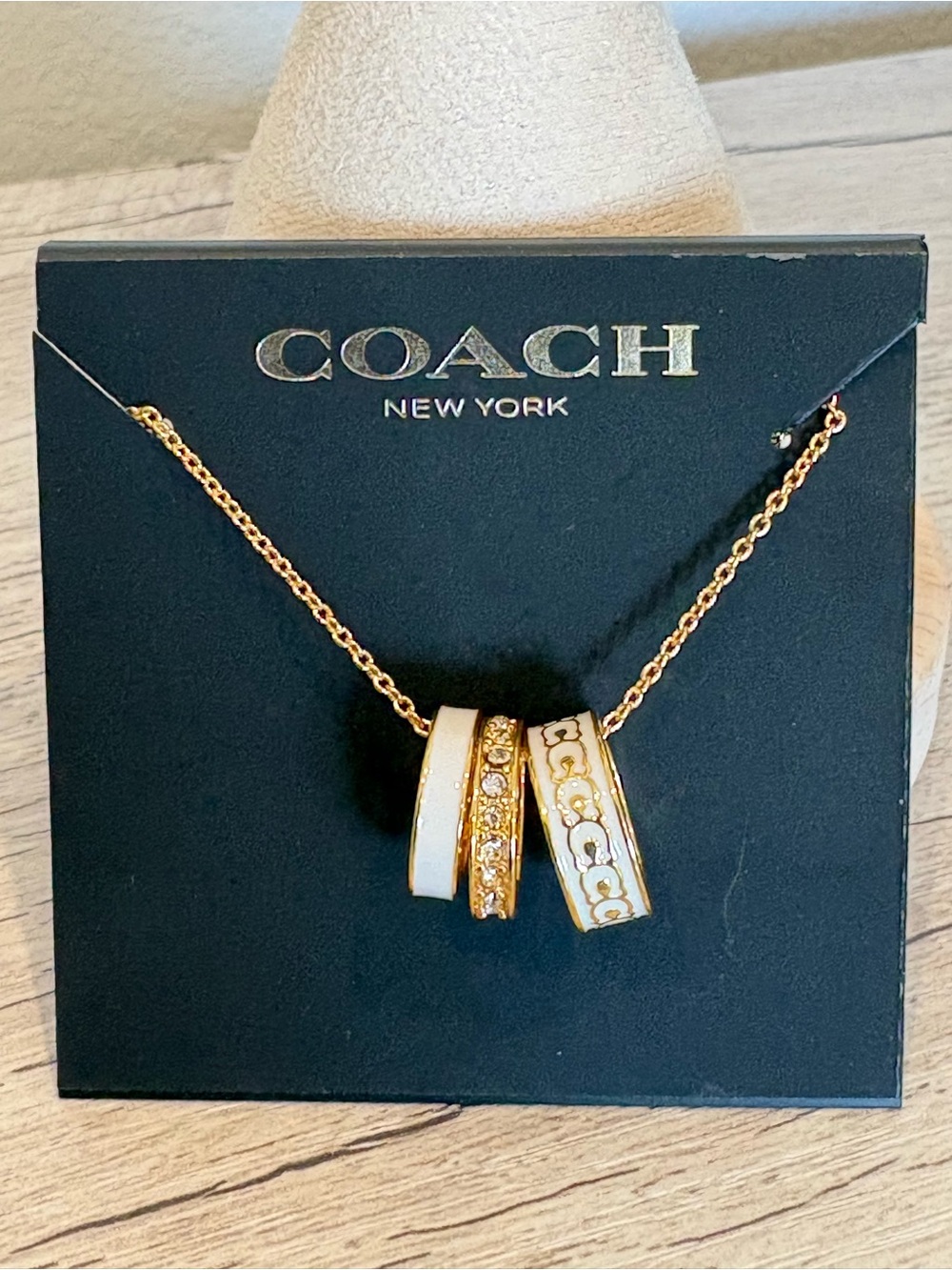 Coach Gold-Tone Necklace with White Enamel and Crystal Logo Ring Pendants